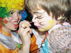 girl draws a clown on her face