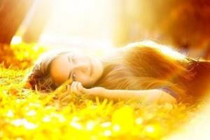 девушка лежит на лужайке в солнечных лучах