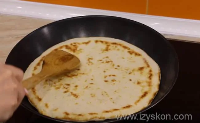 Cooking delicious pizza in a frying pan with sour cream
