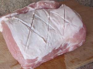 Make cross-shaped cuts on a piece of pork tenderloin
