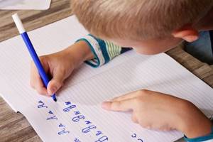 The child learns to write letters beautifully