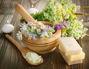 Herbs in a wooden mortar, salt, natural soap