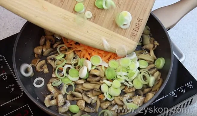 Выкладываем в сковороду к грибам лук-порей и морковь